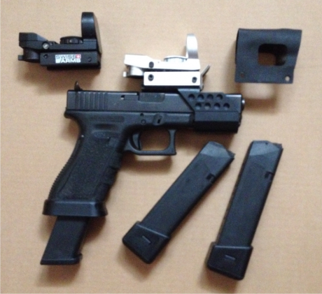 Glock 17c, con fresado en corredera y taladros que mejoran rendimiento.
Retenidas de cargador y corredera 00