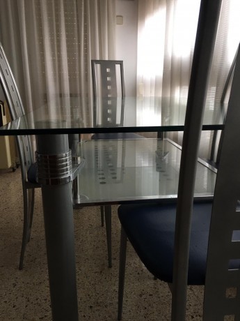 Mesa de cristal y su juego de cuatro sillas de diseño, prácticamente nuevas,por 250 euros,se encuentra 20