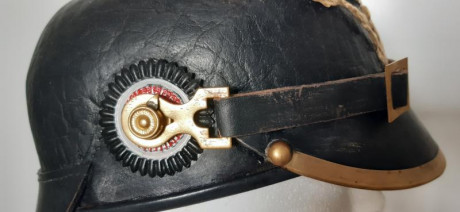 Pickelhaube modelo 1895 con cocardas del Reich (rojo, blanco y negro) y de Prusia (negro, blanco y negro).
Tiene 01